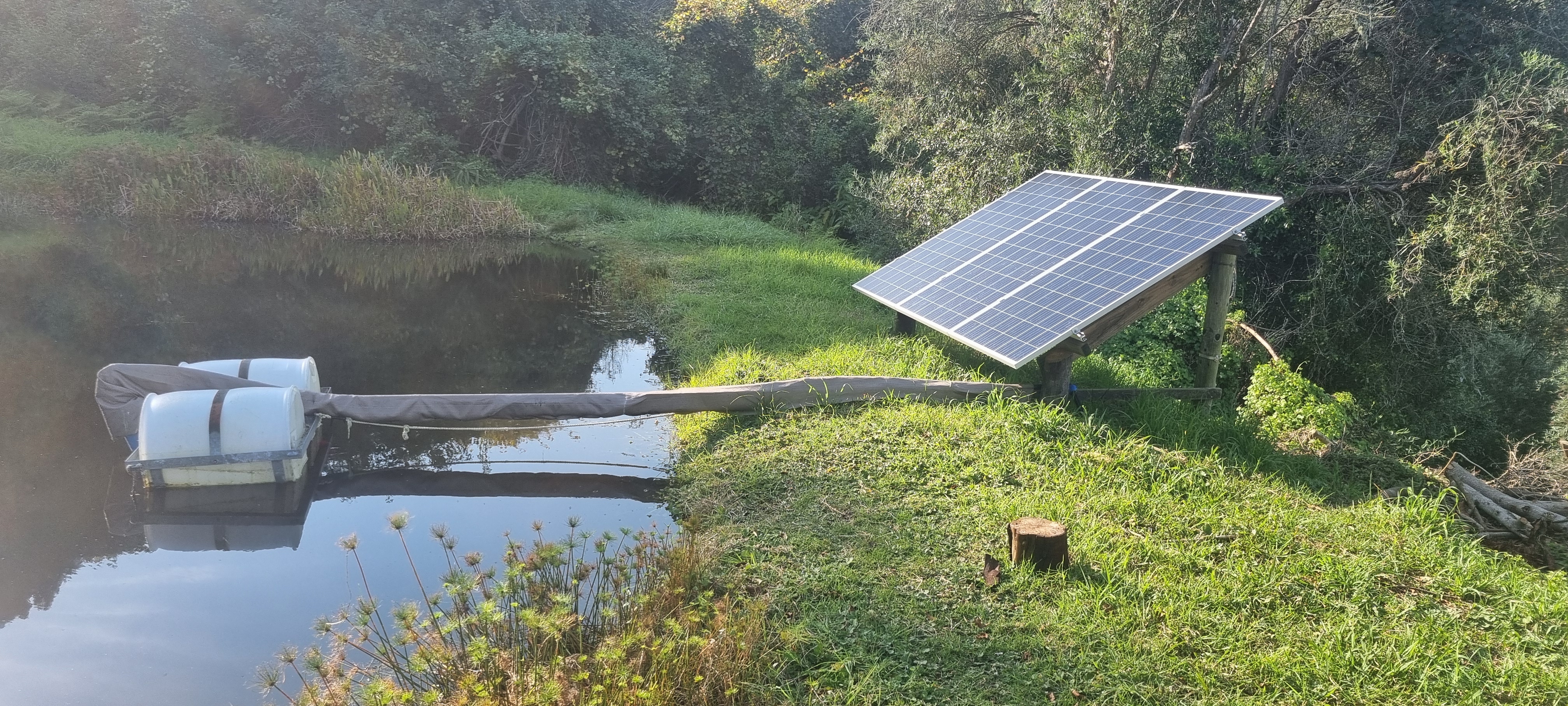 A solar-powered pump lifts water from the dam to three elevated Jojo tanks — the system runs without grid power.